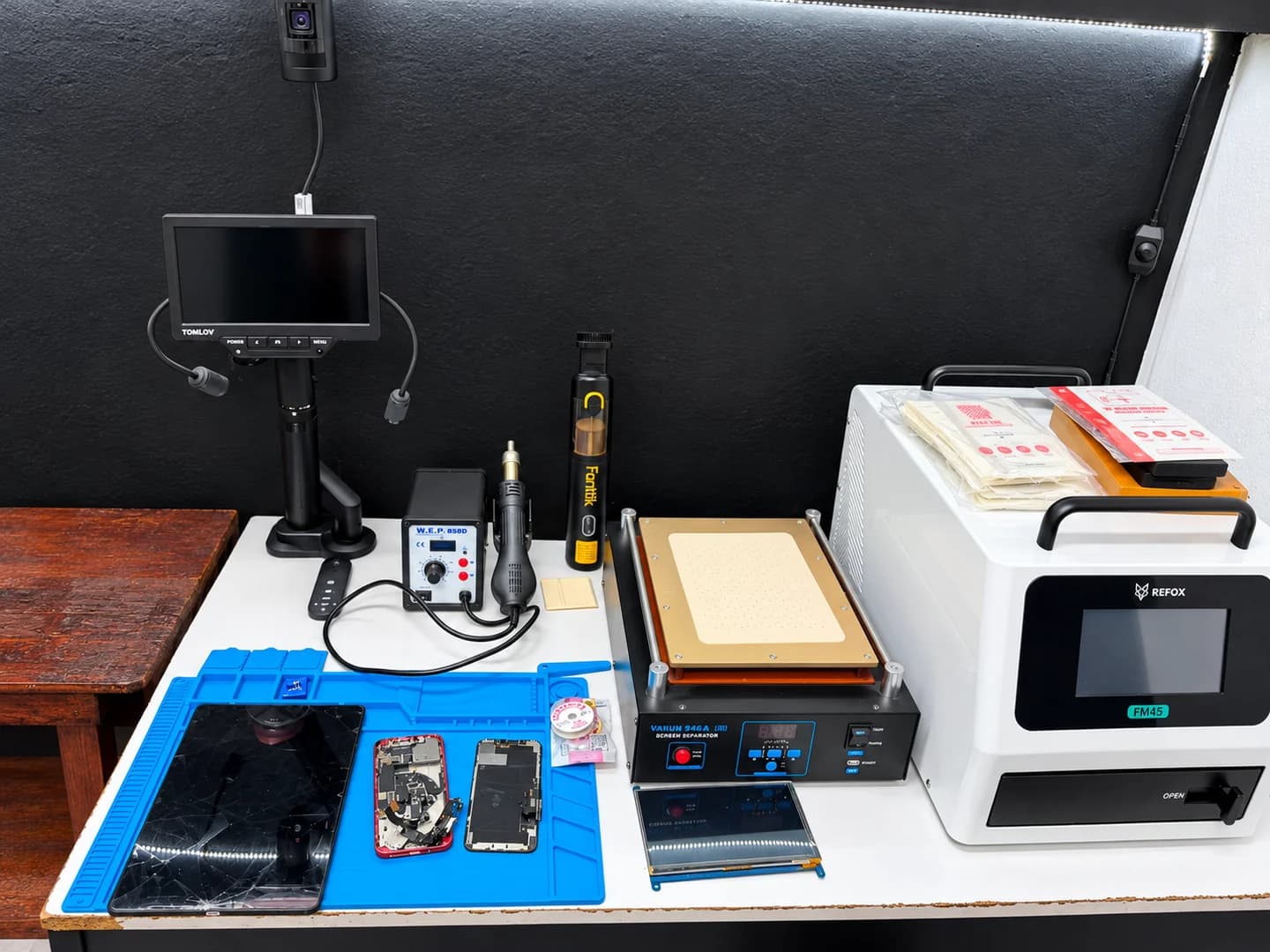 Mesa de trabajo de Fixly con herramientas y equipo para reparar celulares.